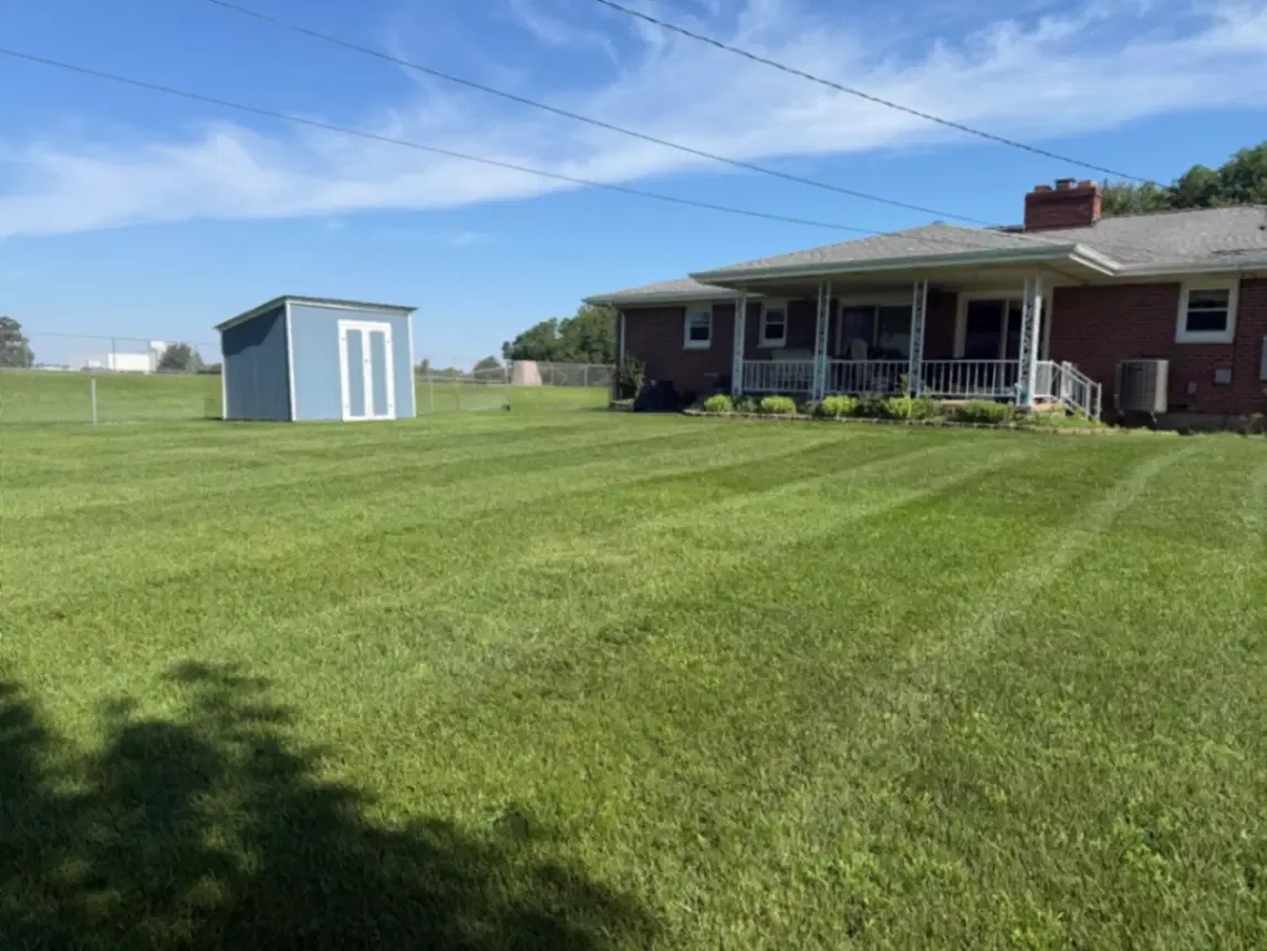 Residential lawn service with crisp mowing stripes at a brick ranch in Fulton, Illinois